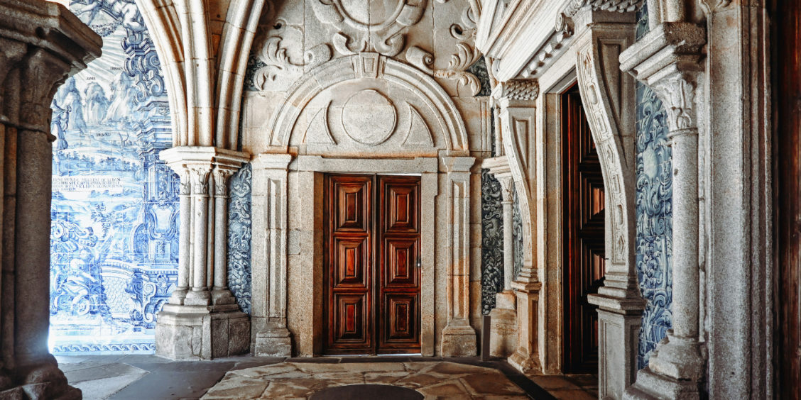Chiostro gotico della Cattedrale di Porto con archi in pietra e pareti decorate da azulejos.
