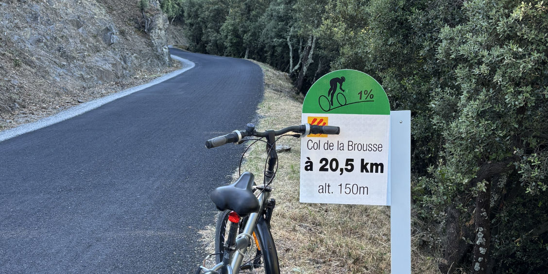 Bicicletta accanto al cartello stradale per il Col de la Brousse, lungo un percorso ciclistico nel Massiccio delle Albères vicino a Le Boulou.