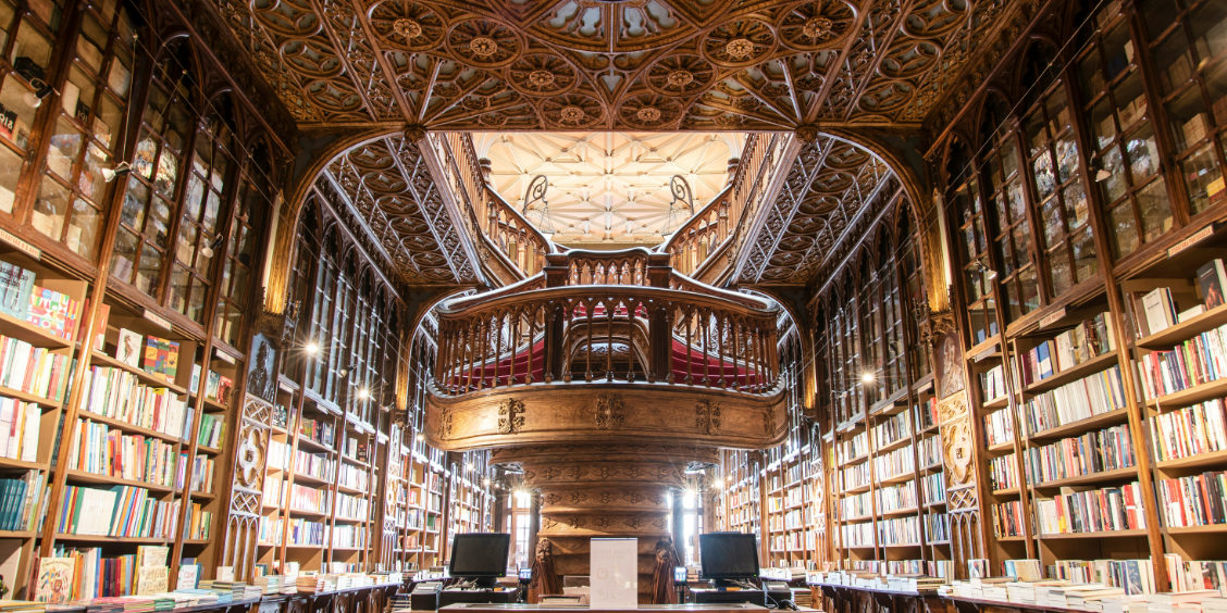 Interno della storica Libreria Lello a Porto con la celebre scala in legno intagliato e gli scaffali di libri.