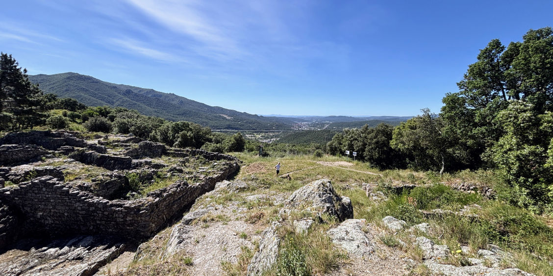Splendida panoramica sul Massiccio delle Albères nei pressi di Le Boulou, con antiche rovine in pietra in primo piano.